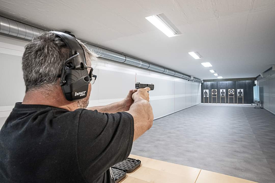 Schütze zielt mit einer Pistole in der Shooting Point Indoor-Schiessanlage
